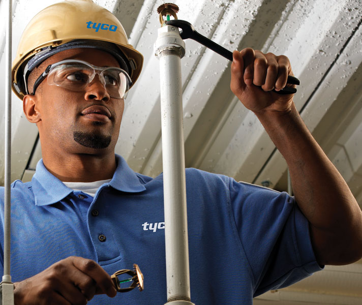 Pipe worker with wrench working on a sprinkler